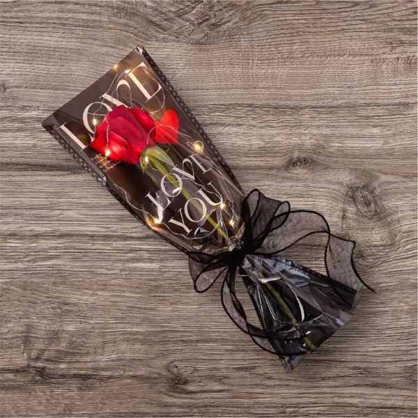 Single red rose wrapped in black paper with a ribbon