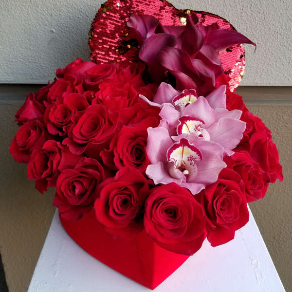 Red roses with pink orchids in a heart-shaped box