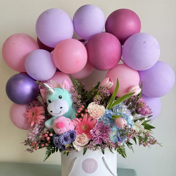 Balloon and flower arrangement with a plush unicorn in a white hatbox