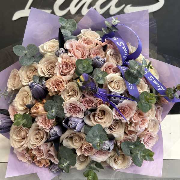 Bouquet of blush roses and carnations with purple accents and eucalyptus