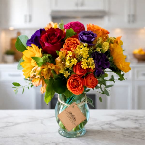 Colorful bouquet of roses and sunflowers in a glass vase