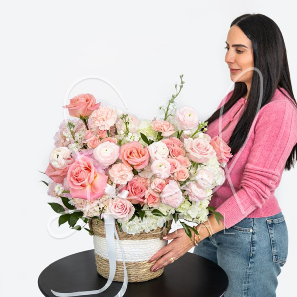 Large pink and white rose arrangement in a woven basket