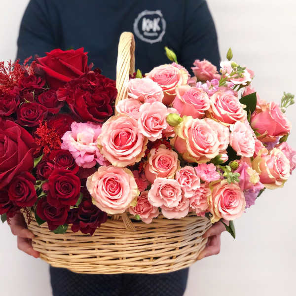 Basket of red and pink roses with small filler flowers