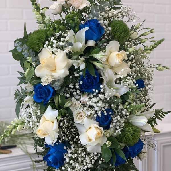 Large standing arrangement of blue and cream roses with white lilies
