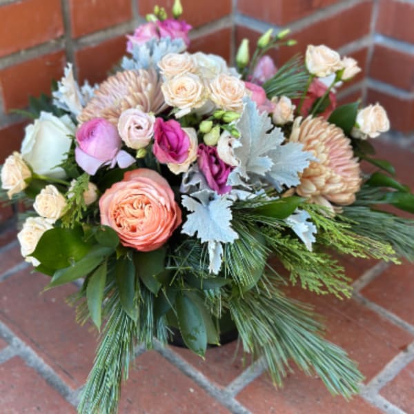 Mixed bouquet of pink and peach flowers with greenery