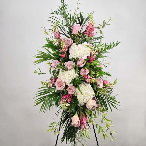 Tall pink and white floral standing spray on a black easel