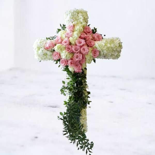 Cross-shaped floral arrangement with pink roses and white hydrangeas