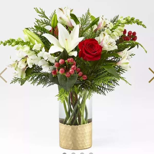 Red rose and white lily arrangement in a glass vase with gold wrap