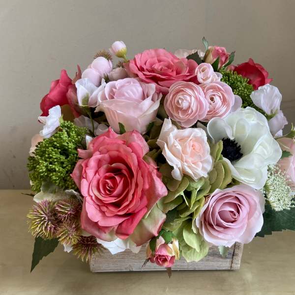 Pink and white rose arrangement in a wooden box