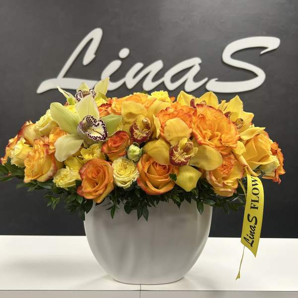 Orange and yellow floral arrangement in a white vase