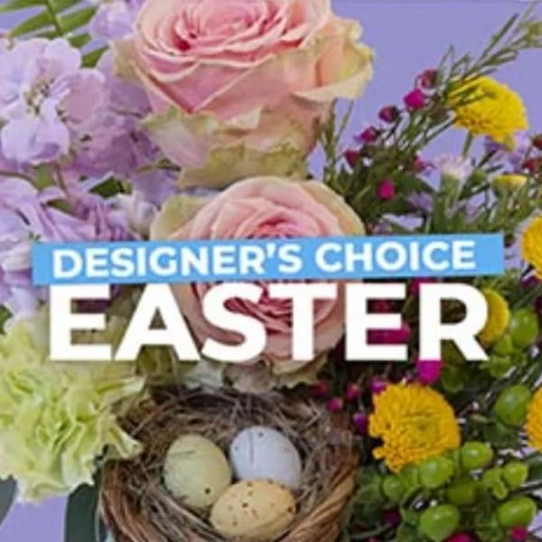 Easter designer’s choice floral product with pastel blooms and a small nest of speckled eggs.
