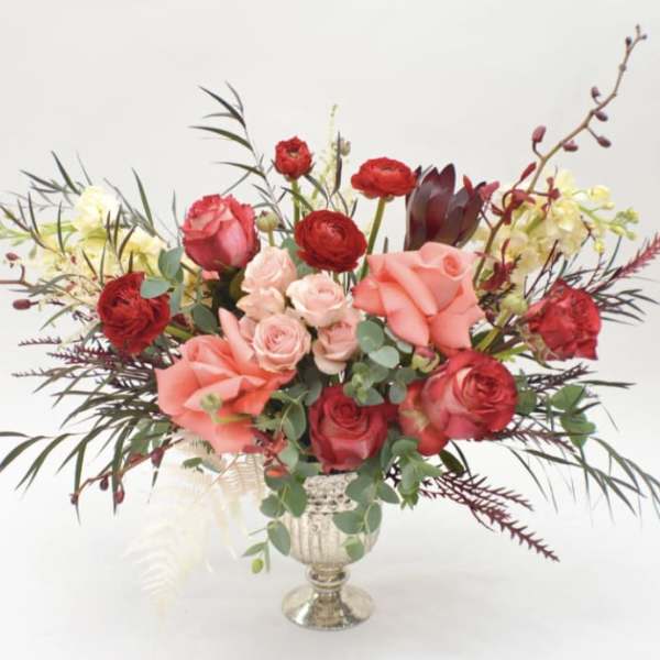 Mixed bouquet of red and pink roses in a silver vase