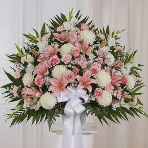 Large pink and white floral spray with a white ribbon bow
