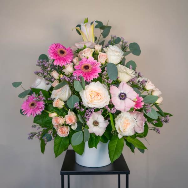 Pink and white mixed flower arrangement in a white vase