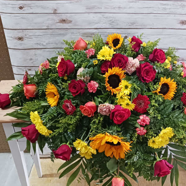 Large mixed floral arrangement with red roses and sunflowers