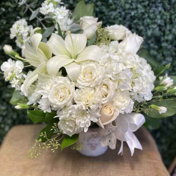 White floral bouquet with roses, lilies, and chrysanthemums in a vase