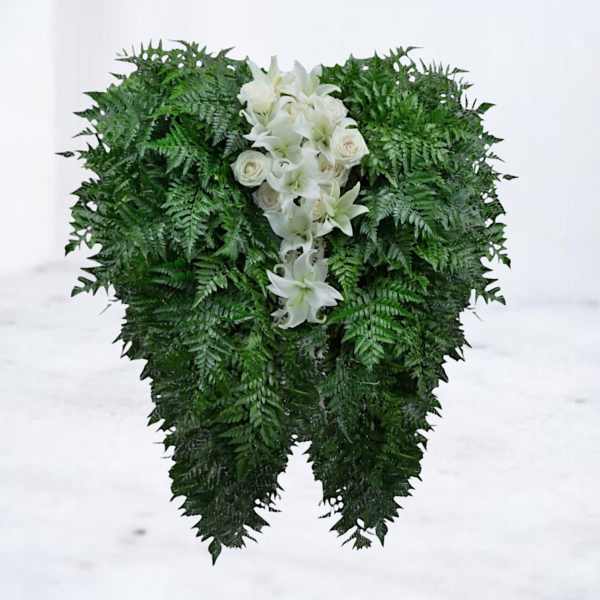 White lilies and roses arranged in a dense green standing spray