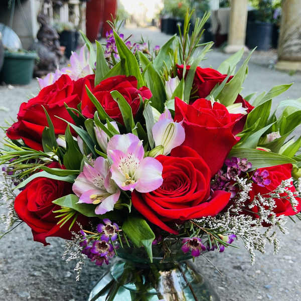 Red roses and pink alstroemeria in a glass vase