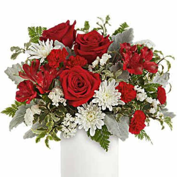 Red roses, red carnations, and white mums arranged in a white cylinder vase