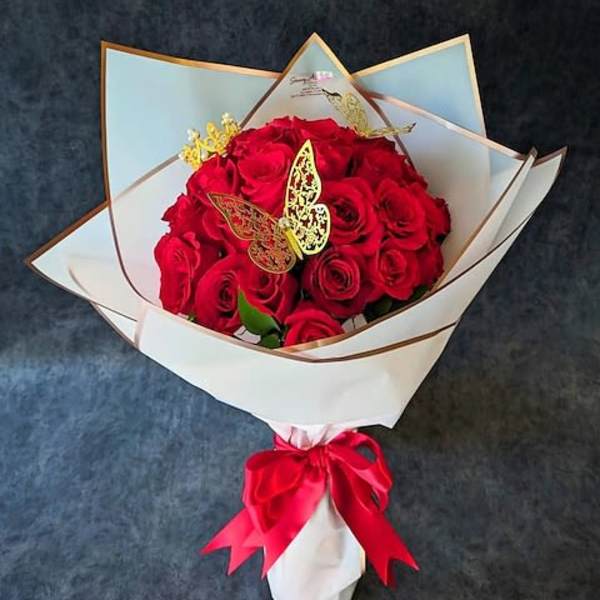 Bouquet of red roses wrapped in white paper with a red ribbon