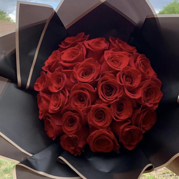 Bouquet of red roses wrapped in black paper