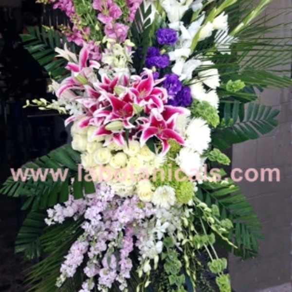 Tall standing floral spray with pink and white lilies and purple accents