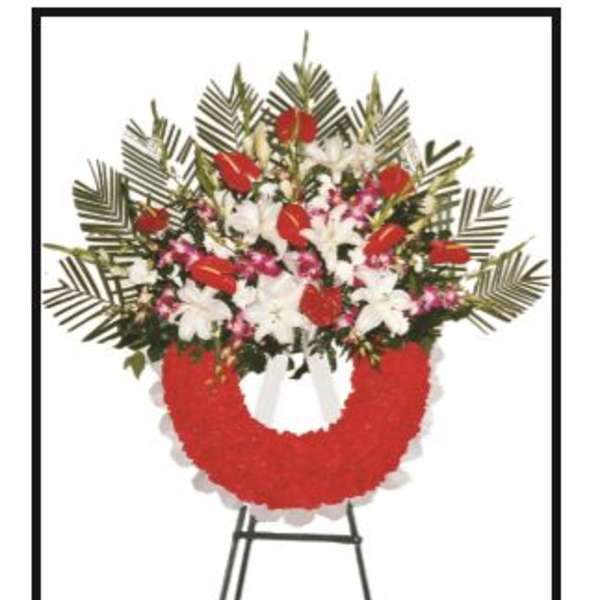 Standing floral wreath with red and white flowers on an easel