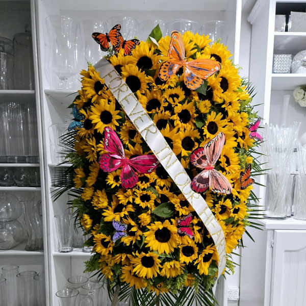 Large sunflower standing spray with a memorial ribbon and butterfly accents