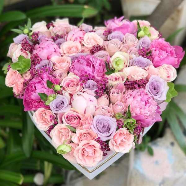 Heart-shaped bouquet of pink and lavender roses with peonies