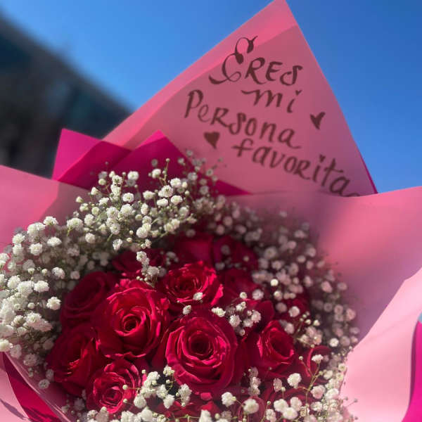 Bouquet of red roses with white baby's breath in pink wrapping
