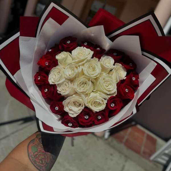 Bouquet of red and white roses wrapped in red and white paper