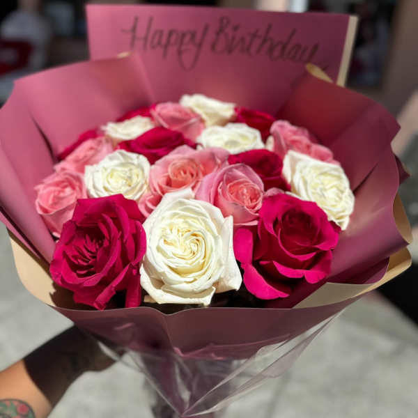 Bouquet of pink, white, and red roses with a birthday card