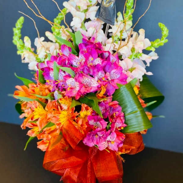 Bright mixed bouquet with pink, orange, and white flowers and a ribbon wrap