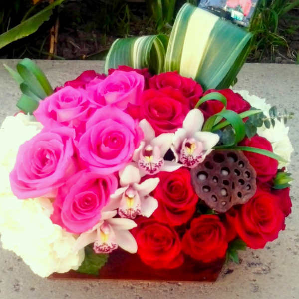 Bouquet of pink and red roses with white orchids and a lotus pod