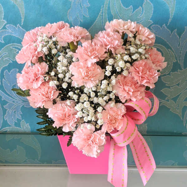 Pink carnation bouquet in a bright pink box with a ribbon bow