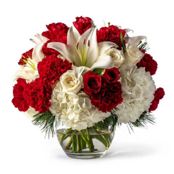 Red carnations, white lilies, roses, and hydrangeas in a glass vase