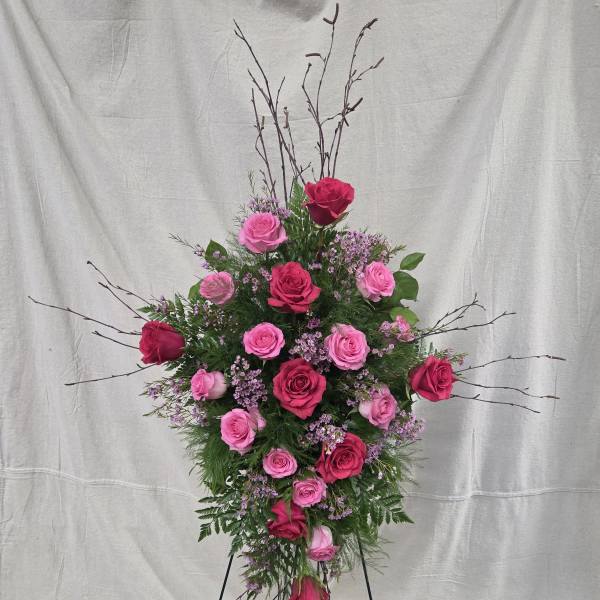 Tall standing spray of hot pink and light pink roses on a metal easel