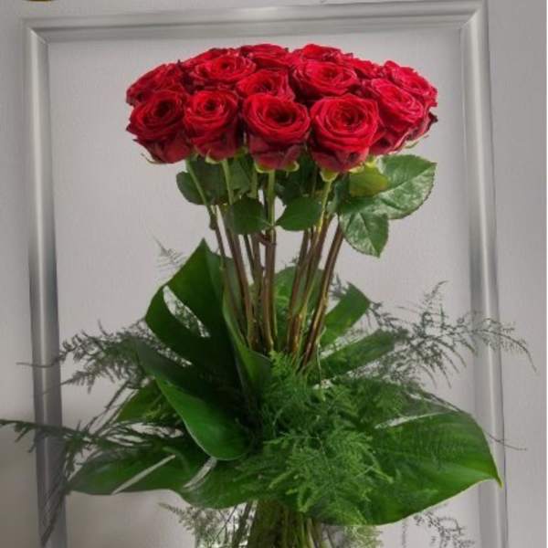 Tall bouquet of red roses in a clear glass vase