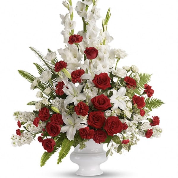Red roses and white gladiolus in a white urn vase