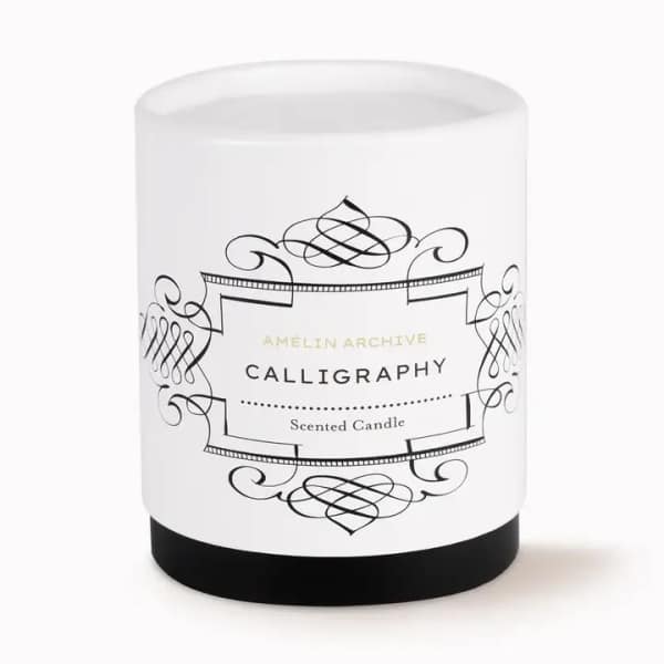 White scented candle in a glass jar with black label design