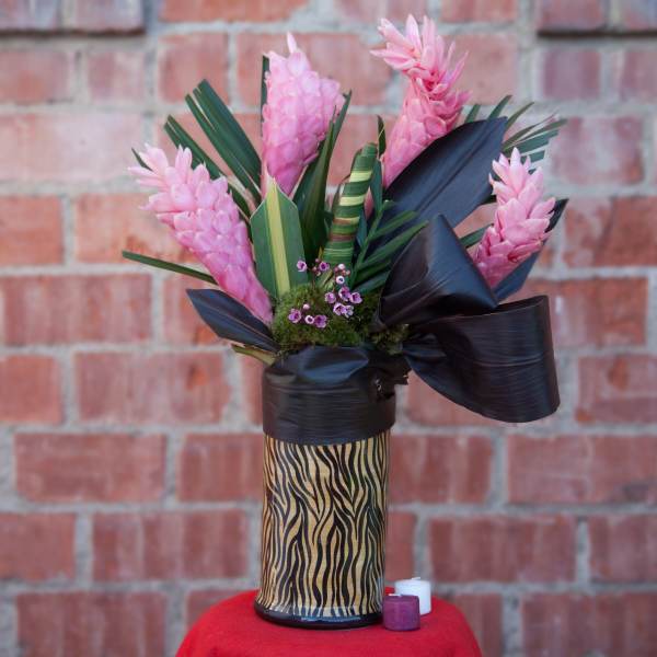 Pink tropical flowers in a zebra-print vase with black ribbon