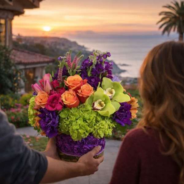 Colorful mixed bouquet in a vase held at a doorway overlooking the ocean