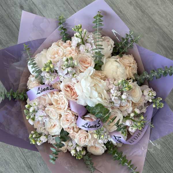 Bouquet of pale peach and white roses with eucalyptus in lavender wrap