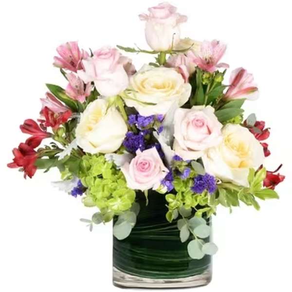 Mixed pink and white roses in a glass vase with purple accents