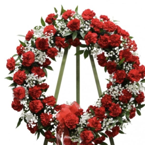 Red carnation funeral wreath with white baby's breath on a standing easel