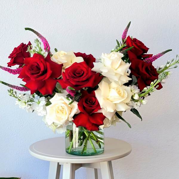 Red and white roses in a clear glass vase