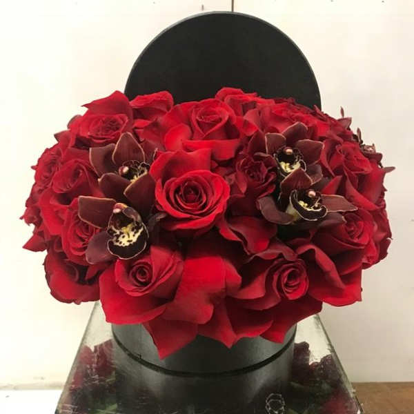 Red rose bouquet with dark orchid accents in a black hat box