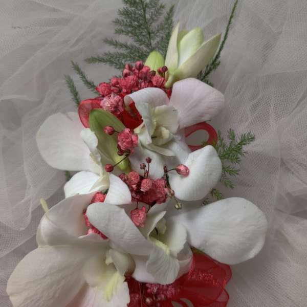 White orchid bouquet with pink accents and red ribbon