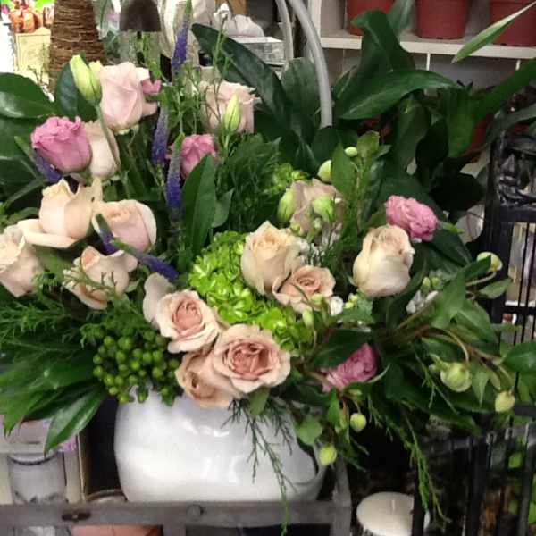 Pink and cream roses arranged in a white vase