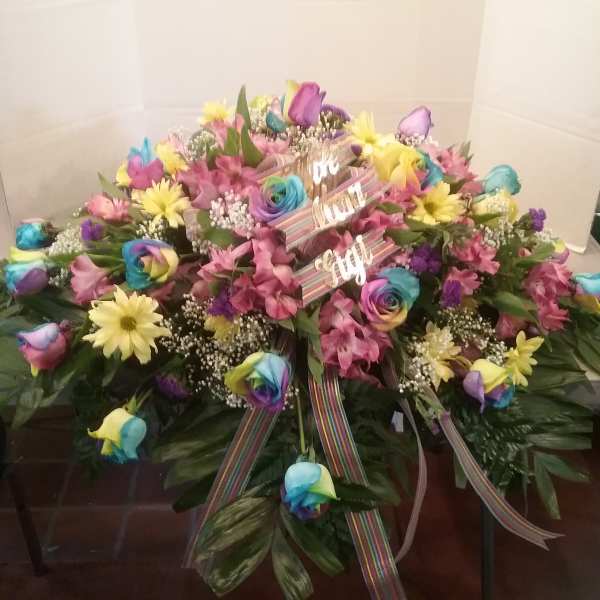 Large colorful floral spray with rainbow roses and pink flowers